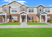 Thumbnail 1 of 31 - The individual portico entrances and well-kept sidewalk and lawn at Muskego School Apartments