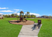 Thumbnail 30 of 31 - playground and bench in the green space at Muskego School Apartments