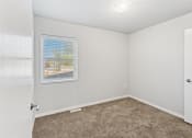 Thumbnail 8 of 31 - a carpeted bedroom with a window and overhead light
