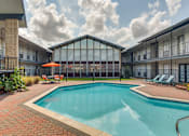 Thumbnail 3 of 11 - A swimming pool surrounded by a glass wall and a red umbrella.