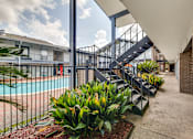 Thumbnail 4 of 11 - A pool area with a staircase and plants.