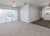 Thumbnail 7 of 11 - A spacious room with a ceiling fan and a chandelier.