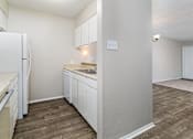 Thumbnail 9 of 11 - A kitchen with white cabinets and a refrigerator.