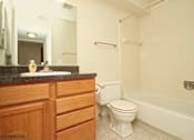 Thumbnail 12 of 27 - A white toilet sits next to a white bathtub in a bathroom.