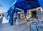 Thumbnail 15 of 33 - A blue canopy is set up over a table with chairs.