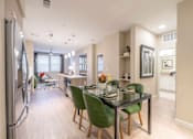Thumbnail 2 of 33 - A modern kitchen with a dining table and chairs.