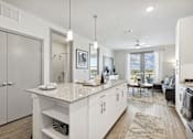 Thumbnail 2 of 14 - Living room with white kitchen island and granite countertops, Ironcrest, Texas