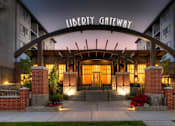 Thumbnail 1 of 22 - Liberty Gateway Apartments, Salt Lake City, Utah, entrance to the Liberty Gateway building is adorned with lights and red flowers.