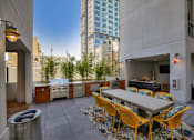 Thumbnail 1 of 73 - A patio with a table and chairs.is surrounded by buildings.