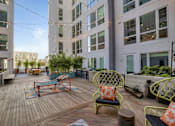 Thumbnail 3 of 73 - A patio with a table and chairs. is surrounded by buildings.