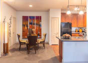 Thumbnail 25 of 49 - a kitchen and dining room with a table and chairs and a painting on the wall