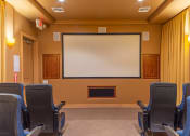 Thumbnail 8 of 49 - a theater room with chairs and a large screen