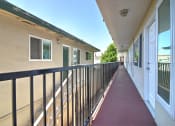Thumbnail 2 of 31 - a balcony with a red walkway next to a building with white doors