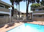 Thumbnail 4 of 22 - A swimming pool in front of apartment buildings.