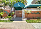 Thumbnail 1 of 30 - The entrance to a building with a green awning and a sign