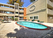 Thumbnail 6 of 30 - A pool in a courtyard surrounded by buildings.