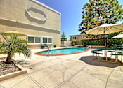 Thumbnail 7 of 30 - A pool with a table and chairs around it.