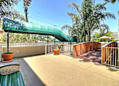 Thumbnail 11 of 30 - A patio with a green awning and a bench.