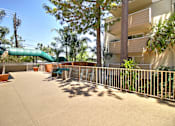 Thumbnail 13 of 30 - A green slide is in the middle of a concrete courtyard.