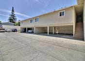 Thumbnail 4 of 37 - A large parking lot in front of a two-story building with a garage.