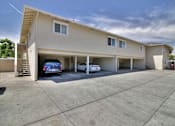 Thumbnail 6 of 37 - A two-story building with a garage and a car parked in it.