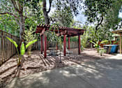 Thumbnail 8 of 22 - A backyard with a wooden pergola and a bench.