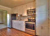 Thumbnail 7 of 22 - a kitchen with white cabinets and stainless steel appliances