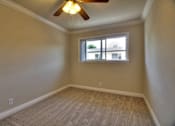 Thumbnail 9 of 22 - an empty bedroom with a window and a ceiling fan