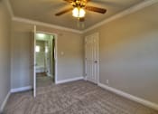 Thumbnail 10 of 22 - a bedroom with a ceiling fan and a door to a hallway