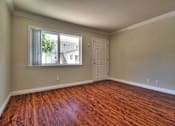 Thumbnail 12 of 22 - an empty living room with wooden floors and a window