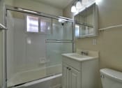 Thumbnail 16 of 22 - a bathroom with a shower sink and mirror and a toilet