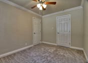Thumbnail 18 of 22 - a bedroom with two doors and a ceiling fan