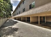 Thumbnail 14 of 25 - A long concrete walkway leads to a building with a row of windows.