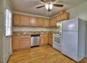 Thumbnail 5 of 15 - A kitchen with wooden cabinets and a white refrigerator.