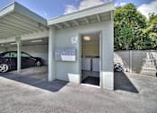 Thumbnail 14 of 15 - A car is parked in a garage with a white car parked inside.