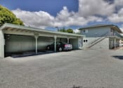 Thumbnail 13 of 15 - A car is parked in a garage under a covered area.