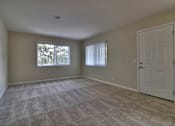 Thumbnail 7 of 15 - A room with a carpeted floor and a white door.
