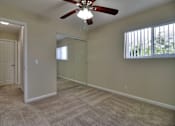 Thumbnail 10 of 15 - A room with a ceiling fan and a carpeted floor.