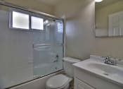 Thumbnail 11 of 15 - A white toilet sits next to a sink in a bathroom.