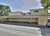 Thumbnail 8 of 22 - A two-story building with a flat roof and a garage door.