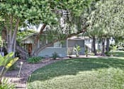 Thumbnail 4 of 42 - A building is surrounded by a green lawn and trees.