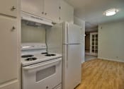 Thumbnail 8 of 21 - A kitchen with a stove and refrigerator built into the wall.