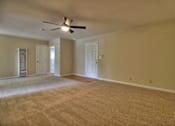 Thumbnail 10 of 21 - A room with a ceiling fan and carpeted floor.
