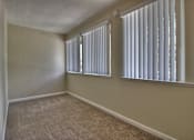 Thumbnail 11 of 21 - A room with a window covered by white blinds.