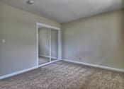 Thumbnail 14 of 21 - A room with a carpeted floor and a sliding glass door.