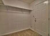 Thumbnail 18 of 21 - A white door is on the right side of a room with a carpeted floor.