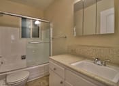 Thumbnail 19 of 21 - A bathroom with a sink, toilet, and shower.