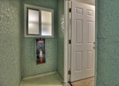 Thumbnail 20 of 21 - A white door is open to a hallway with a poster on the wall.