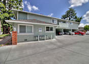 Thumbnail 4 of 21 - A two-story building with a parking lot in front.