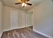 Thumbnail 17 of 21 - an empty living room with a ceiling fan and a door to a closet